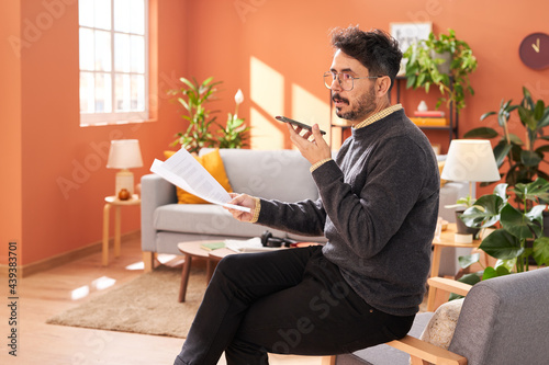 Middle aged freelancer sending voice message at home