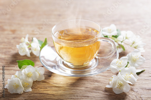 cup of jasmine tea and fresh jasmine flowers