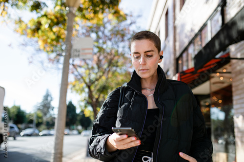 Woman Looks At Her Phone Outside  photo