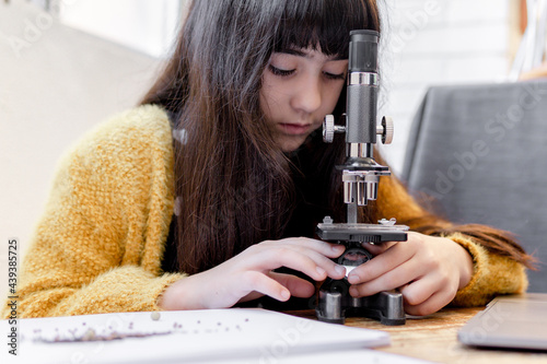 kid Girl Looking seeds in her microscope
 photo