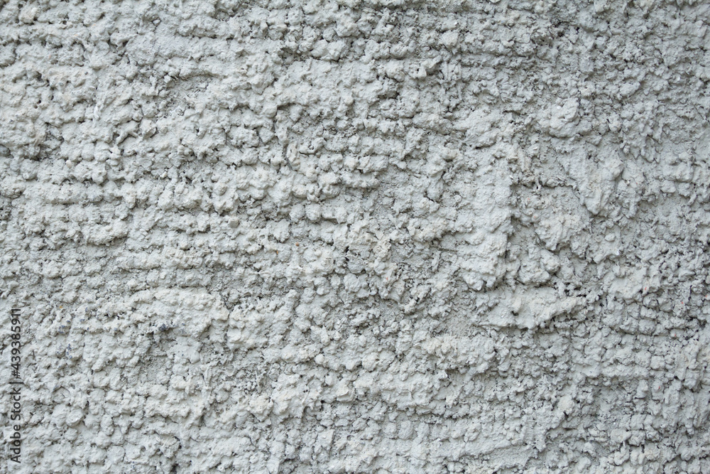 The wall is evenly covered with gray volumetric abstract rough plaster. Background, texture. The wall is evenly covered with gray volumetric abstract rough plaster. Background, texture.