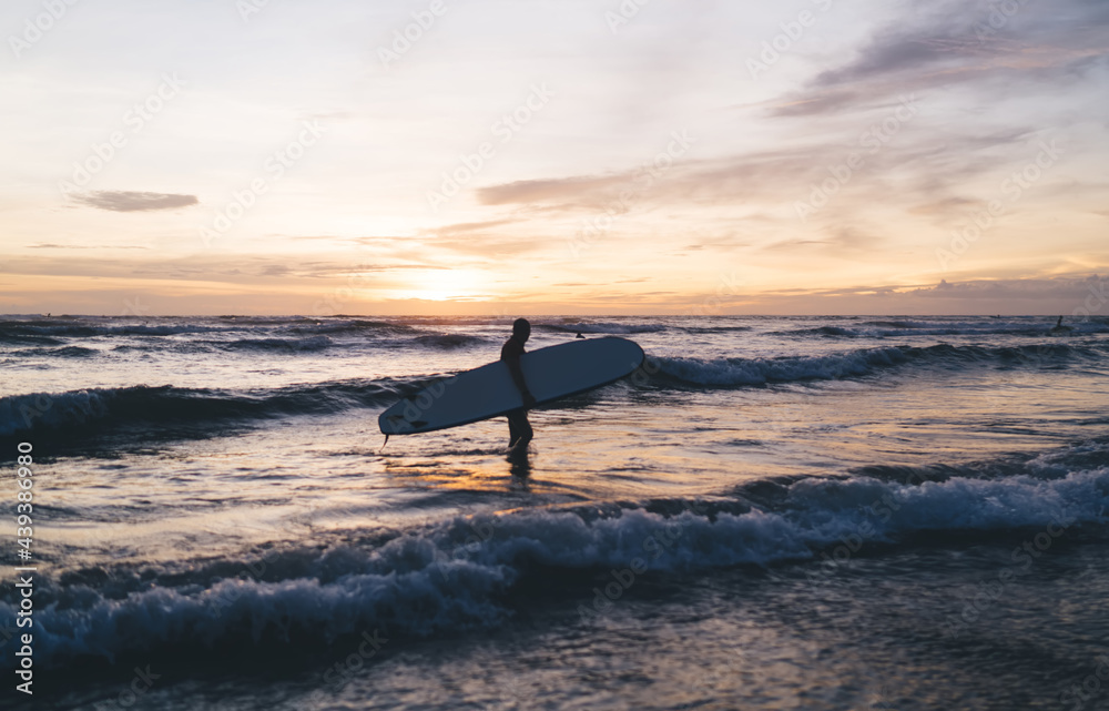 Unrecognizable surfer walking along sea