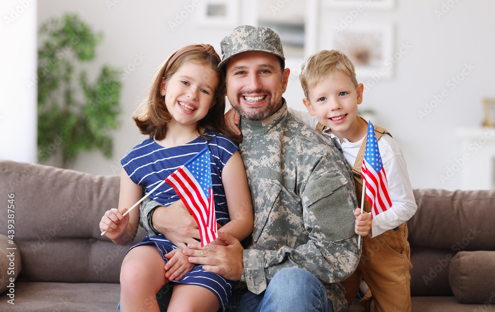 Happy young father in military uniform reunited with cute little children at home