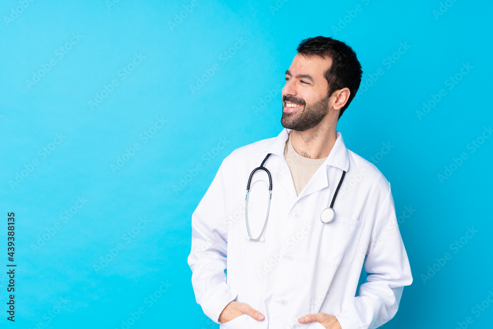 Young caucasian man over isolated background wearing a doctor gown and with stethoscope Young caucasian man over isolated background wearing a doctor gown and with stethoscope