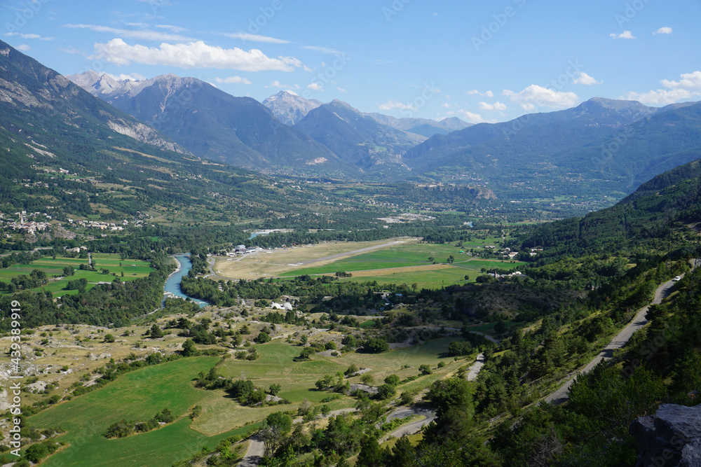view from the top of the mountain of the valley of Guillestre, France with the river and road