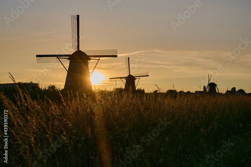 Windmill in the evening with the sun setting in an orange sky