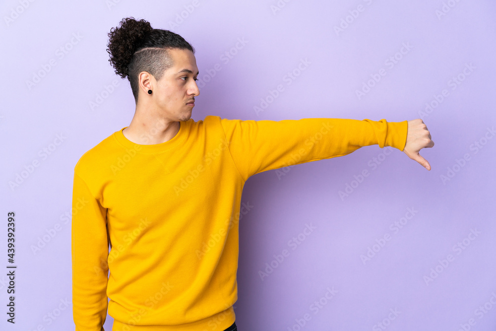 Caucasian man over isolated background showing thumb down with negative expression