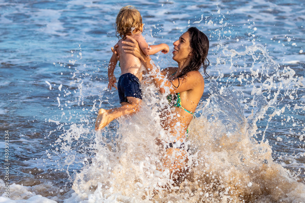 Fototapeta premium MÃE E FILHO BRINCANDO NA PRAIA.