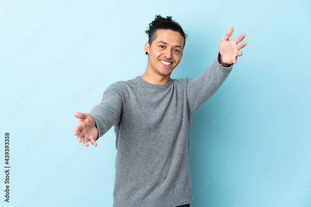 Caucasian man over isolated background presenting and inviting to come with hand Caucasian man over isolated background presenting and inviting to come with hand