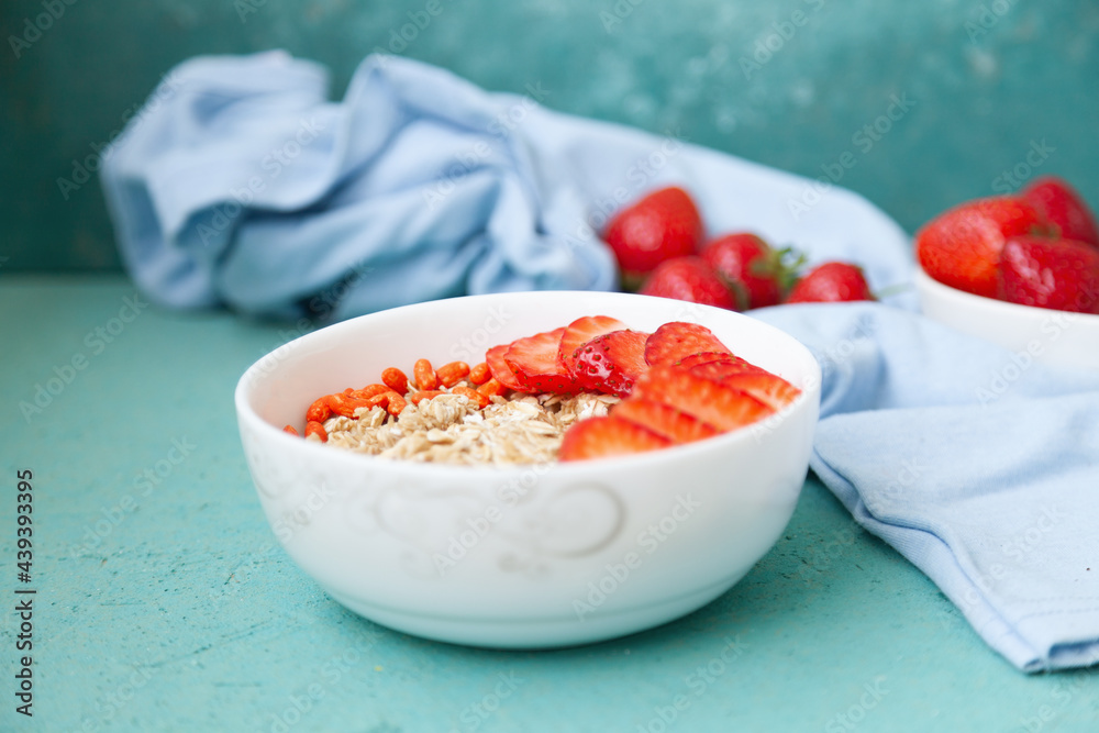 Oatmeal with strawberries, in a bowl on a wooden table background. Healthy breakfast food Oatmeal with strawberries, in a bowl on a wooden table background. Healthy breakfast food