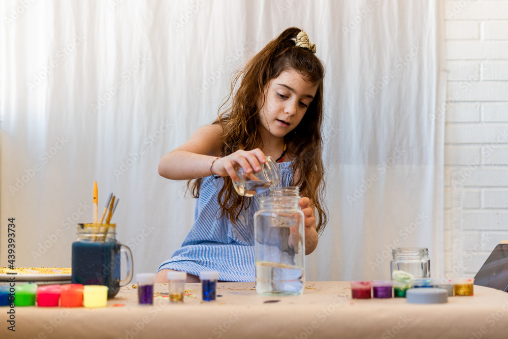 Little girl putting water to make crafts Little girl putting water to make crafts