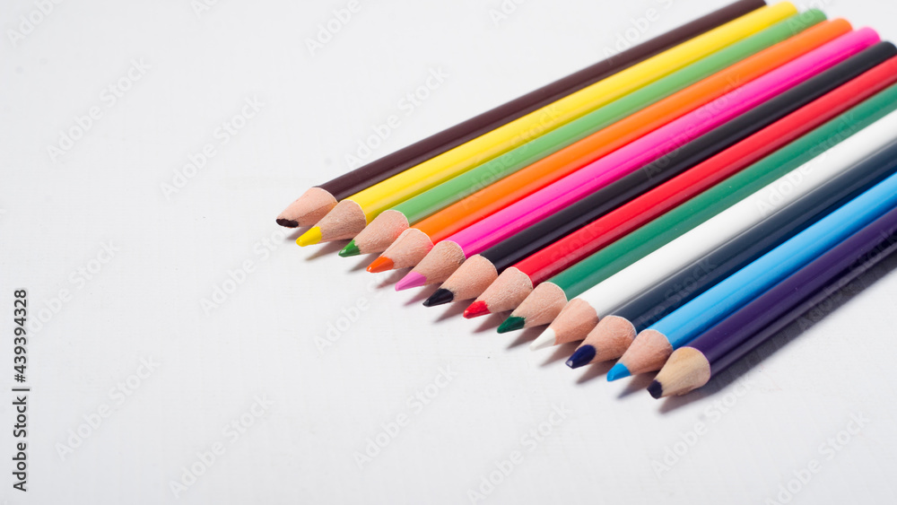 Multi Coloured Pencils arranged in straight-line on white background. education concept. Multi Coloured Pencils arranged in straight-line on white background. education concept.