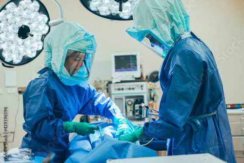 Surgeon and nurse with patient in operating theater photo