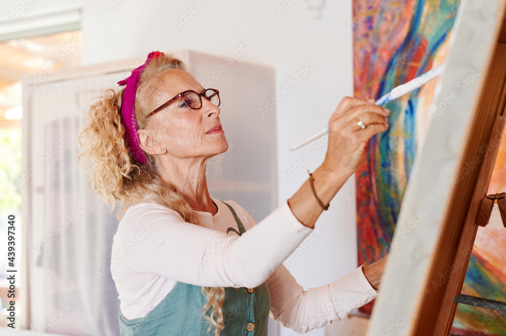 Senior woman painting in her studio Senior woman painting in her studio