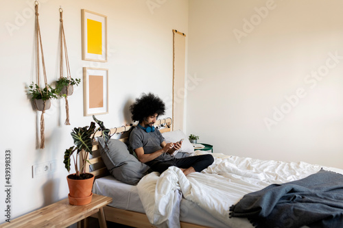 man using smartphone during morning time at bed photo