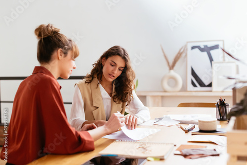 Designers discussing project in workspace