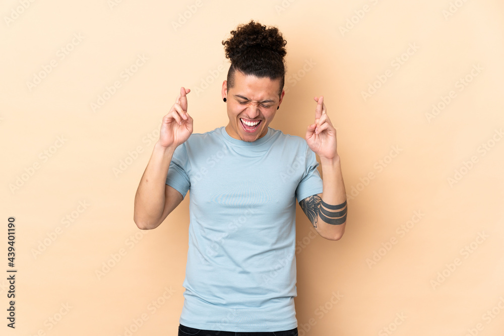 Caucasian man over isolated background with fingers crossing