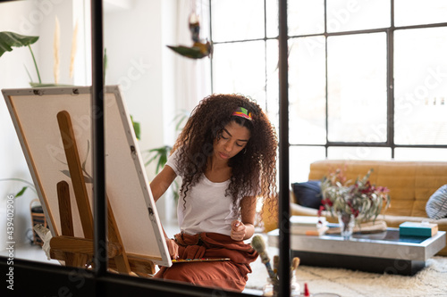 Mixed race Woman painting a picture at her studio. photo