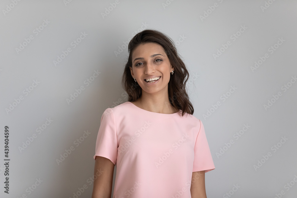 Head shot portrait of smiling Arabian woman with healthy toothy smile and perfect smooth skin on grey studio background isolated, happy beautiful young female looking at camera, natural beauty Head shot portrait of smiling Arabian woman with healthy toothy smile and perfect smooth skin on grey studio background isolated, happy beautiful young female looking at camera, natural beauty