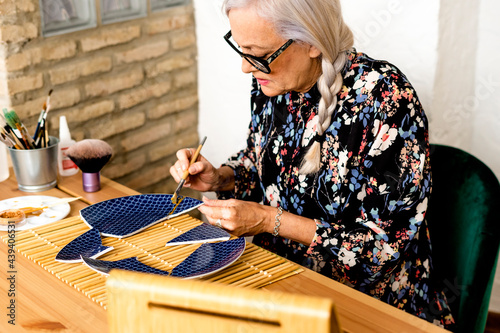 Portrait of hoary woman repairing a broken plate with a millenial japanese technique  photo