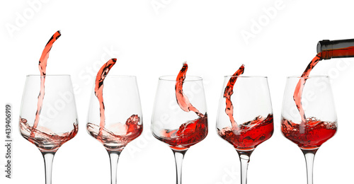 Glasses with splashing red wine on white background