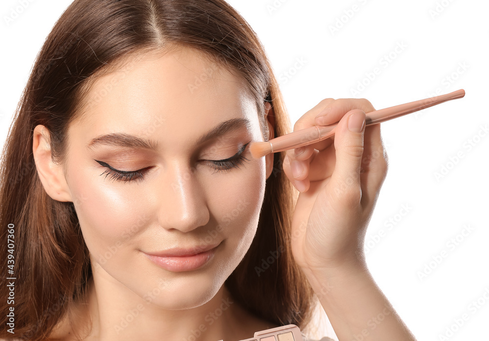 Makeup artist working with beautiful young woman on white background Makeup artist working with beautiful young woman on white background