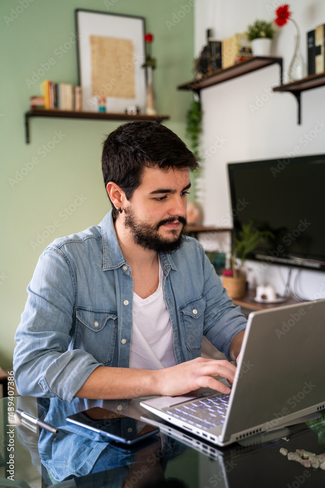 Young man working from home in living room Young man working from home in living room