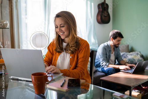 Young couple working from home in living room photo