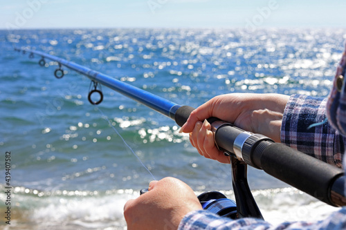 A Female Hand Gripping A Beach Caster Fishing Rod