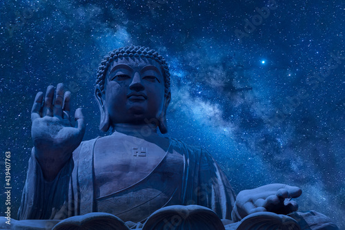 The big Tian Tan Buddha at Po Lin Monastery in Hong Kong during night time. Beautiful night sky with stars and milky way photo