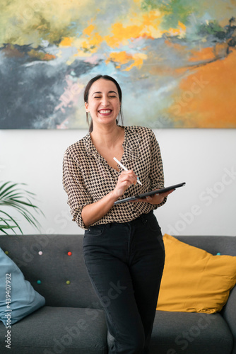 Joyful female clerk with tablet standing in office