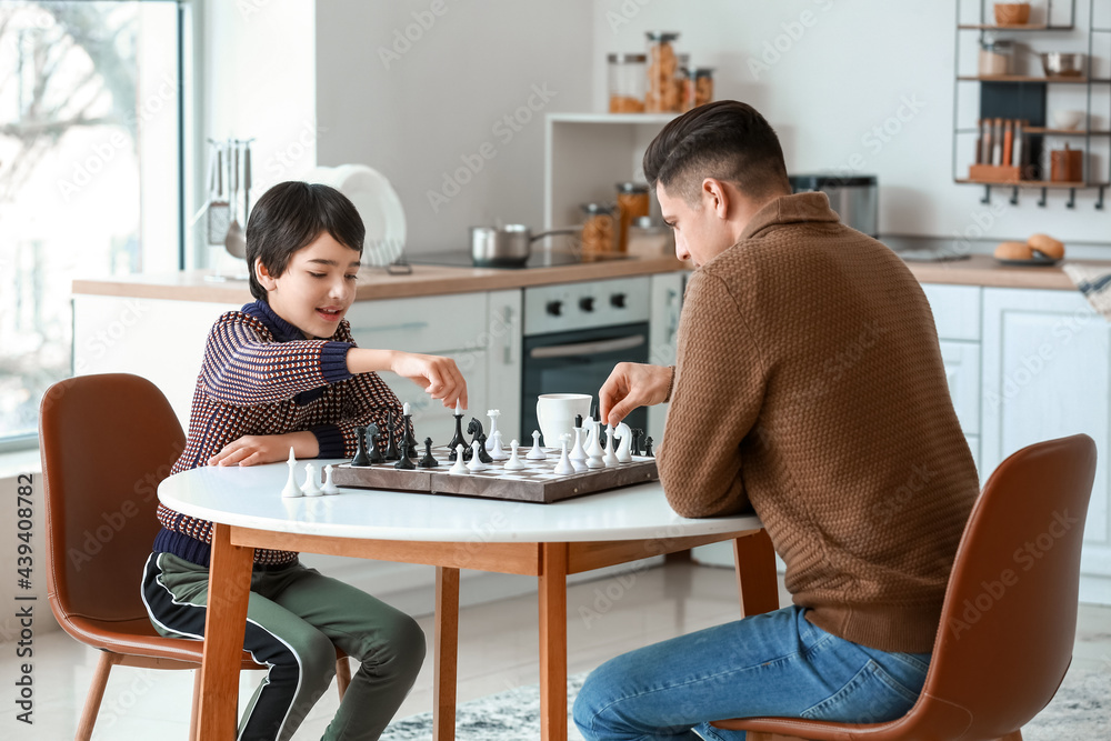 Father and son playing chess in kitchen Father and son playing chess in kitchen