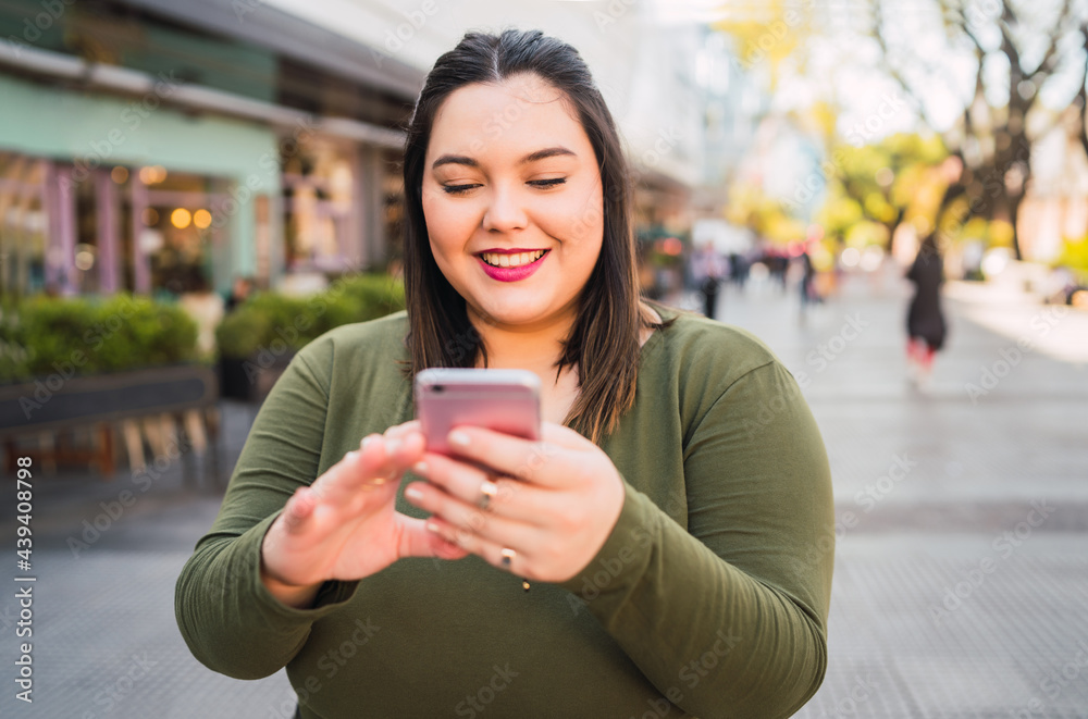 Young plus size woman using her mobile phone. Young plus size woman using her mobile phone.