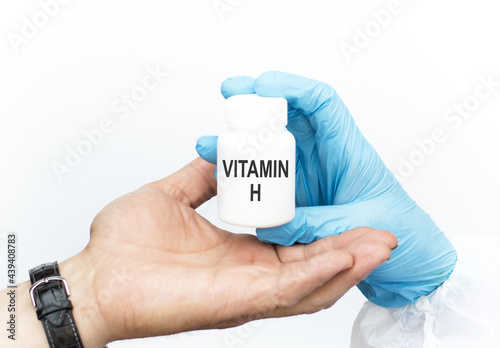essential vitamins and minerals for humans. doctor recommends taking vitamin H to patient, close-up of doctor and patient hands on white background