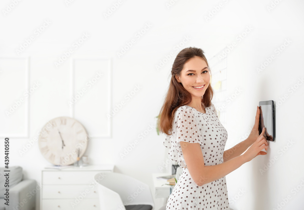 Woman using smart home security system control panel Woman using smart home security system control panel