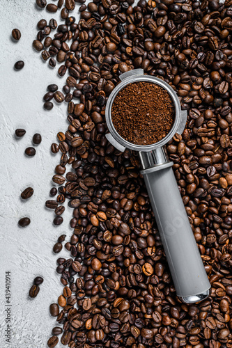 Ground Coffee in Portafilter for Espresso with coffee beans. White background. Top view