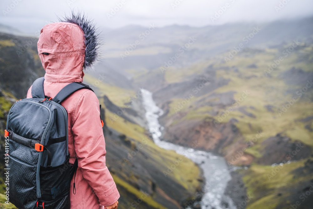 Close up of a woman with backpack enjoying icelandic highland and river fossa close to Haifoss waterfall in Iceland