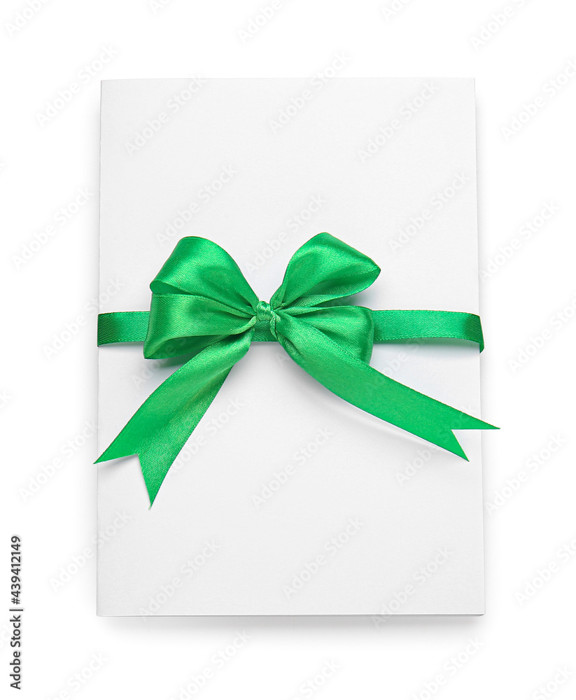 Blank sheet of paper with green ribbon and bow on white background Blank sheet of paper with green ribbon and bow on white background