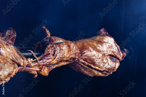 Process of preparing of whole carcasse of Goat on spit close-up, food barbecue concept.