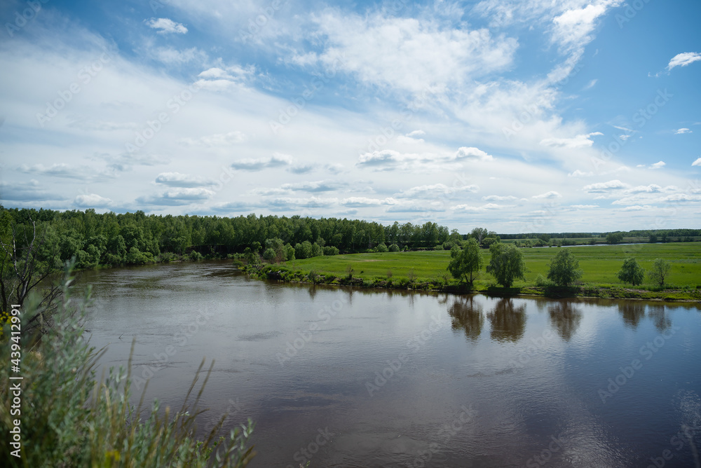 Flowing water of the river under summer blue sky landscape background.