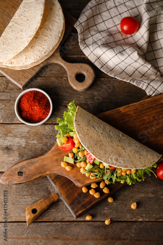 Boards with tasty vegetarian taco on wooden background