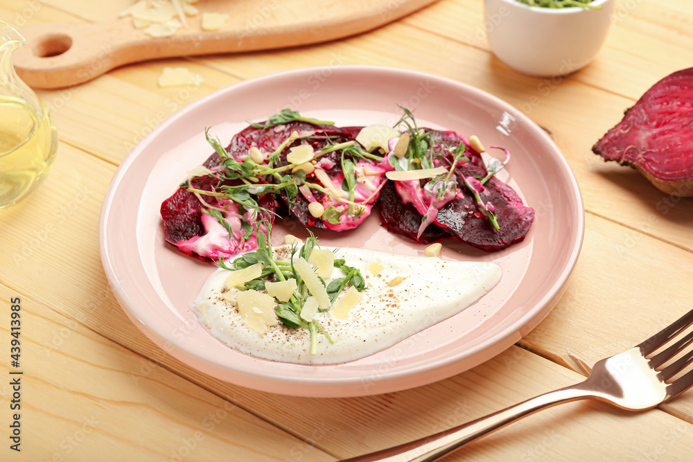 Plate with delicious beetroot carpaccio on wooden background