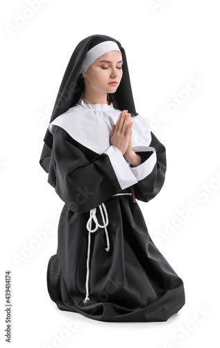Young praying nun on white ...