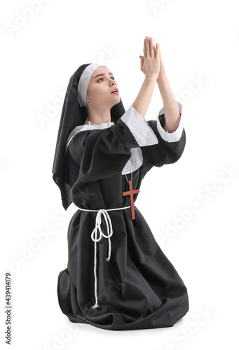 Young praying nun on white ...
