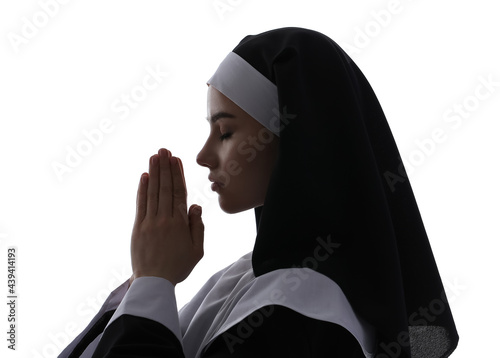 Young praying nun on white ...