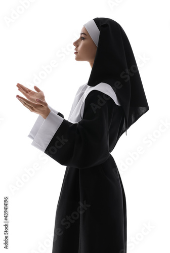 Young praying nun on white ...