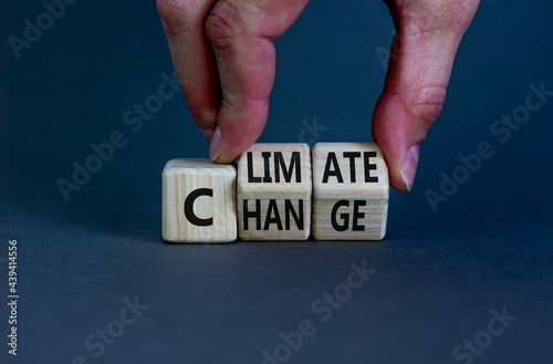 Climate change symbol. Businessman turns cubes with words 'Climate change'. Beautiful grey background. Climate change and ecological concept. Copy space.