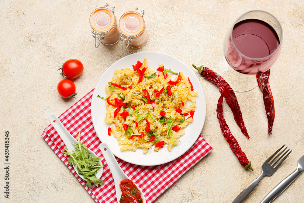 Composition with tasty pasta, glass of wine and ingredients on light background
