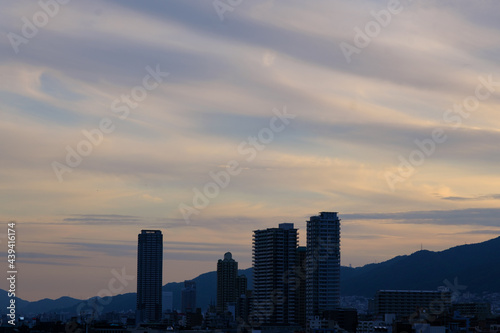 日の入り前の六甲山。西の空と雲がオレンジ色に染まるマジックアワー。高層ビルがシルエットで浮かぶ。１日の終わり。
