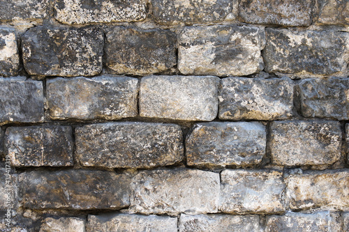 Old wall made of rough stone blocks as a background